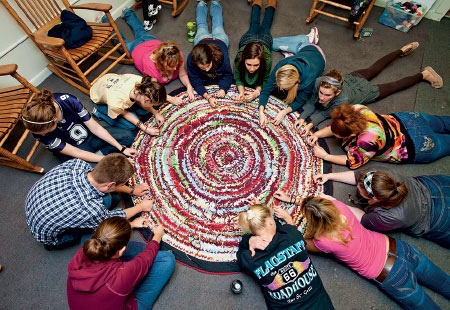 Lafayette students and inmates from Northampton County Correctional Facility craft a rug made from recycled Lafayette T-shirts. The project is part of the course work for Women in the American Criminal Justice System taught by Bonnie Winfield, director of community partnership. 