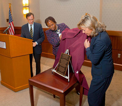 Alma Scott-Buczak ’74 (center) and Nancy Brennan Lund ’74 unveil the plaque as President Daniel H. Weiss looks on.