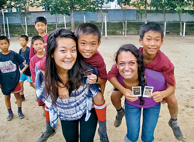 Ellen Song ’13 (left) and Camille DeNardo (daughter of Arlina DeNardo, director of financial aid, now a student at Vanderbilt) enjoy playing games and interacting with children at a middle school in North Korea.
