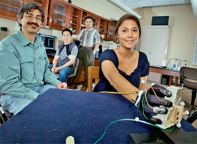 Camille Borland ’13 (right), neuroscience major, demonstrates a computerized glove used in an interdisciplinary study of human grasping behavior led by Luis Schettino (left), assistant professor of psychology, and Yih-Choung Yu (standing, center), associate professor of electrical and computer engineering. Zhao Xin Yin ’13 (seated, center), electrical and computer engineering major, also participated. 