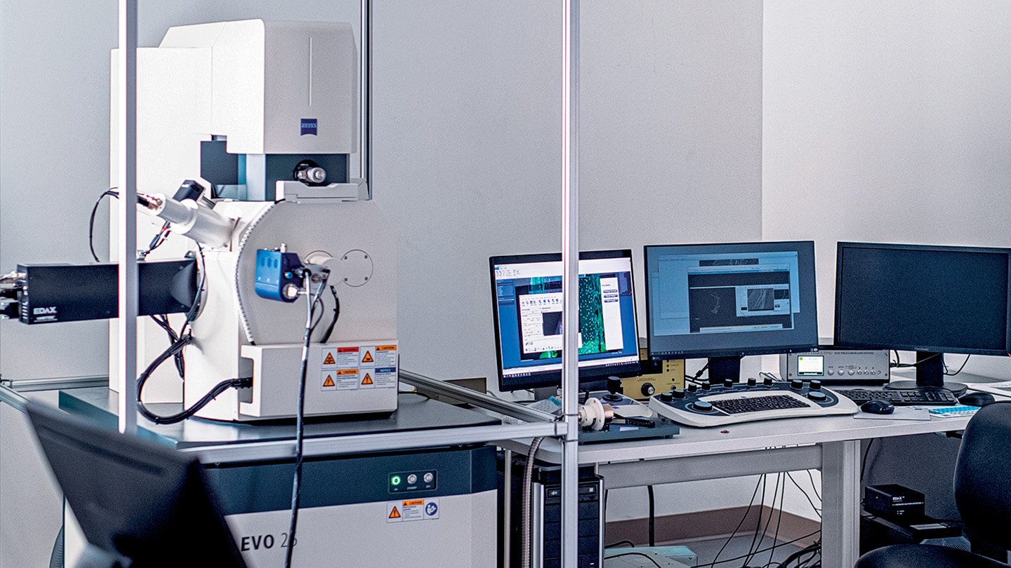 electron scanning microscope and three monitors and keyboards in a lab space