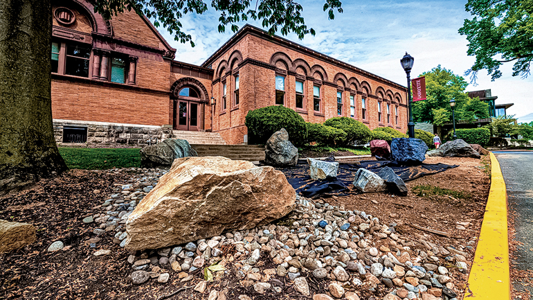 large rocks are arranged in an area outside Van Wickle Hall