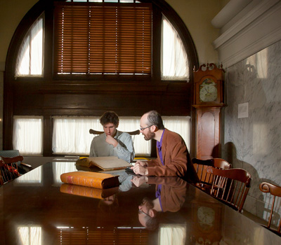 Gavin Jones ’14 (left) and Christopher Phillips review 19th-century circulation records in historic Easton Area Library.