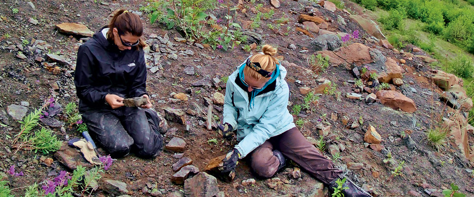 Alexandria Brannick ’12 (left) and Jaclyn White ’13 scour rock piles in Sutton, Alaska, looking for leaf fossil specimens during a research trip last summer.