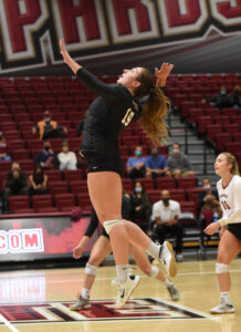 Leanna Deegan ’22 jumps up to serve a volleyball