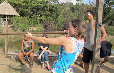 Morgan West ’13 practices her blowgun technique with Chris Vinales ’13 looking on.