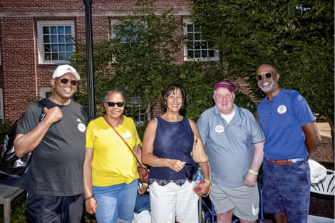a group of alums smile on campus