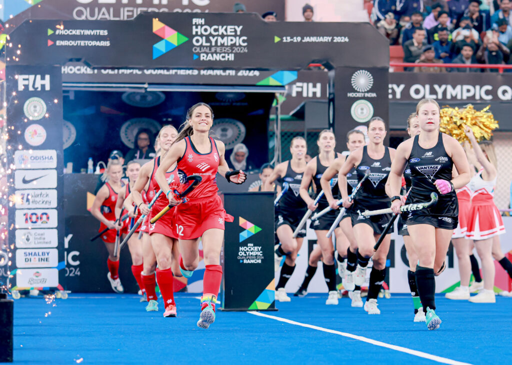 A ptoto of Amanda Magadan Golini ’17 with the U.S. Women’s National Field Hockey Team running out onto the filed.